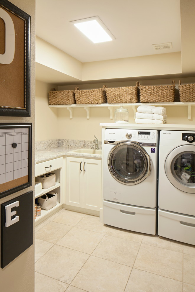 Photo of a traditional l-shaped laundry room in Portland with a drop-in sink, shaker cabinets, white cabinets, beige walls, a side-by-side washer and dryer, beige floor and beige benchtop.