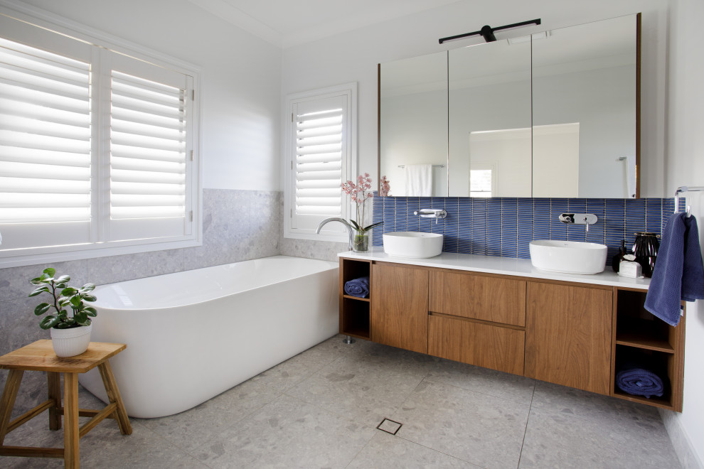 Large trendy 3/4 blue tile gray floor and double-sink bathroom photo in Brisbane with flat-panel cabinets, medium tone wood cabinets, white walls, a vessel sink, quartz countertops, white countertops and a floating vanity