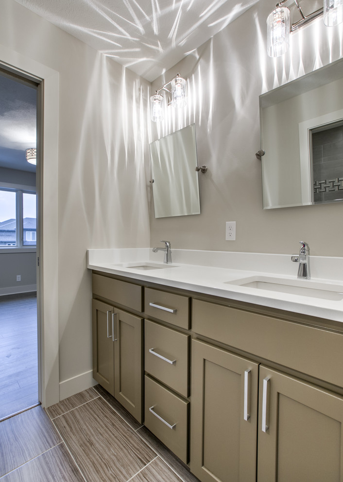 Inspiration for a transitional kids bathroom in Omaha with shaker cabinets, an alcove shower, a two-piece toilet, porcelain floors, an undermount sink, engineered quartz benchtops, a hinged shower door and white benchtops.