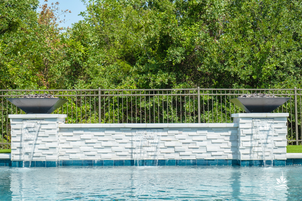 Modelo de piscina natural moderna grande rectangular en patio trasero con paisajismo de piscina y entablado