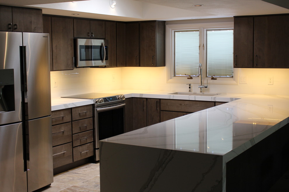 Mid-sized transitional u-shaped ceramic tile open concept kitchen photo in Phoenix with an undermount sink, flat-panel cabinets, gray cabinets, quartz countertops, white backsplash, porcelain backsplash, stainless steel appliances and a peninsula
