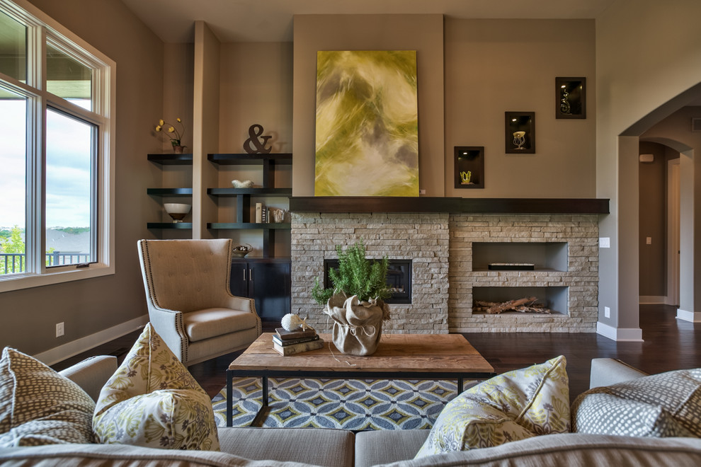 This is an example of a mid-sized transitional living room in Omaha with beige walls, dark hardwood floors, a ribbon fireplace and a stone fireplace surround.