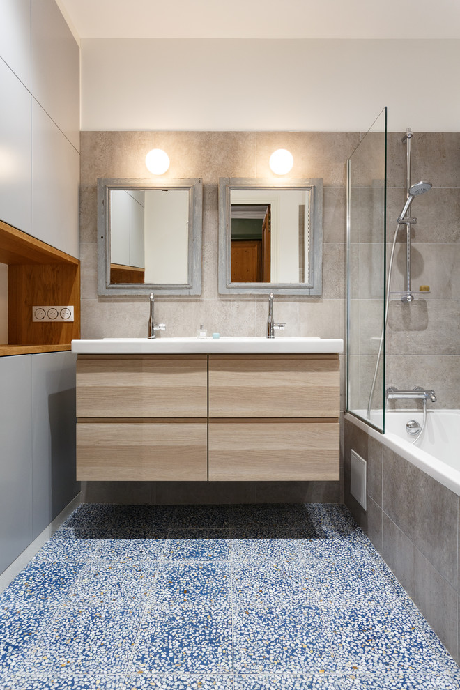 Inspiration for a small modern master bathroom in Paris with flat-panel cabinets, beige cabinets, an undermount tub, a shower/bathtub combo, a two-piece toilet, gray tile, ceramic tile, grey walls, terrazzo floors, a console sink, solid surface benchtops, blue floor and white benchtops.