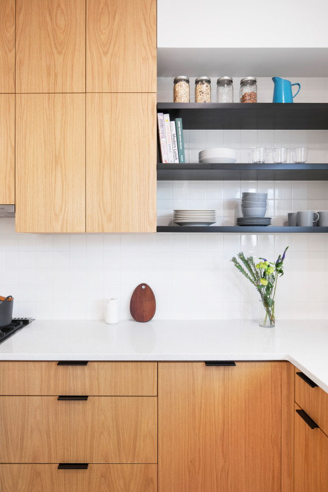 Contemporary l-shaped eat-in kitchen in New York with an undermount sink, flat-panel cabinets, light wood cabinets, quartz benchtops, white splashback, subway tile splashback, stainless steel appliances, cement tiles, pink floor and white benchtop.