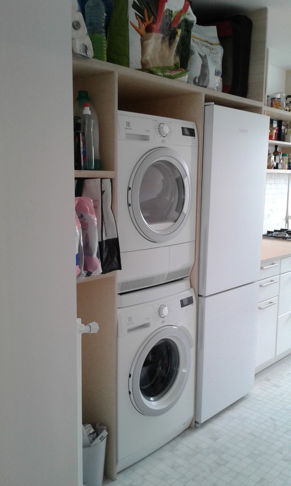 Photo of a mid-sized contemporary l-shaped laundry room in Paris with a drop-in sink, beaded inset cabinets, white cabinets, wood benchtops, multi-coloured splashback, matchstick tile splashback and ceramic floors.