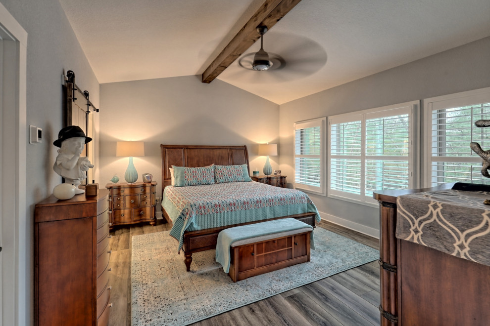 Photo of a large arts and crafts master bedroom in Atlanta with grey walls, vinyl floors, grey floor and exposed beam.