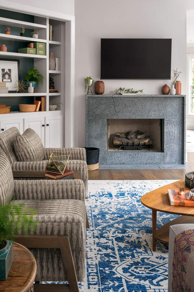 Inspiration for a mid-sized midcentury open concept family room in Nashville with grey walls, dark hardwood floors, a standard fireplace, a stone fireplace surround, a wall-mounted tv and grey floor.