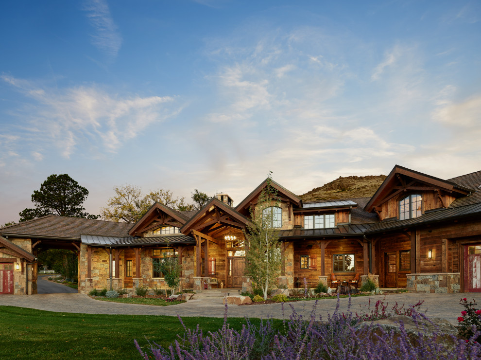 Huge mountain style multicolored two-story stone and shingle exterior home photo in Denver with a shingle roof and a brown roof