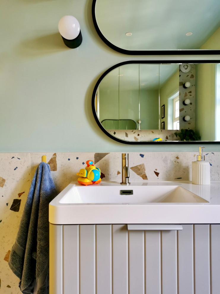 На фото: детская ванная комната среднего размера в скандинавском стиле с серыми фасадами, накладной ванной, открытым душем, инсталляцией, разноцветной плиткой, керамогранитной плиткой, синими стенами, полом из керамогранита, монолитной раковиной, столешницей из искусственного камня, разноцветным полом, открытым душем, белой столешницей, акцентной стеной, тумбой под две раковины и подвесной тумбой