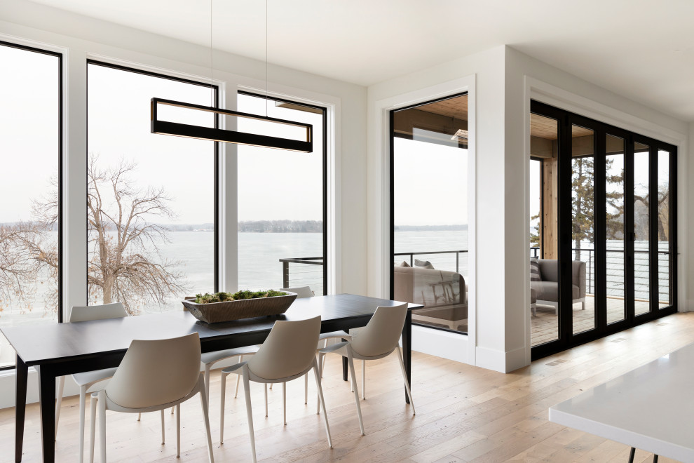 Trendy medium tone wood floor and brown floor dining room photo in Minneapolis with white walls