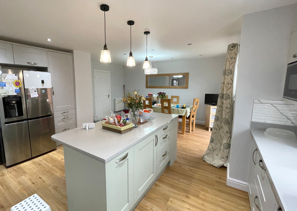 Photo of a medium sized contemporary kitchen/diner in Other with grey cabinets, granite worktops, laminate floors, an island and grey worktops.