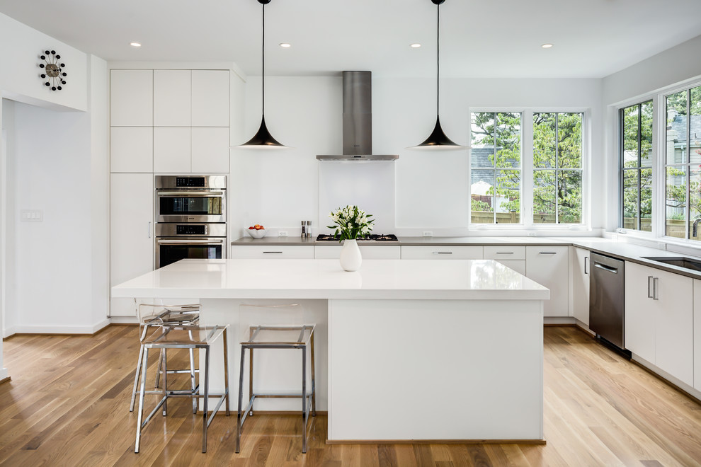 Design ideas for a mid-sized modern l-shaped open plan kitchen in DC Metro with an undermount sink, flat-panel cabinets, white cabinets, quartzite benchtops, stainless steel appliances, light hardwood floors, with island and beige floor.