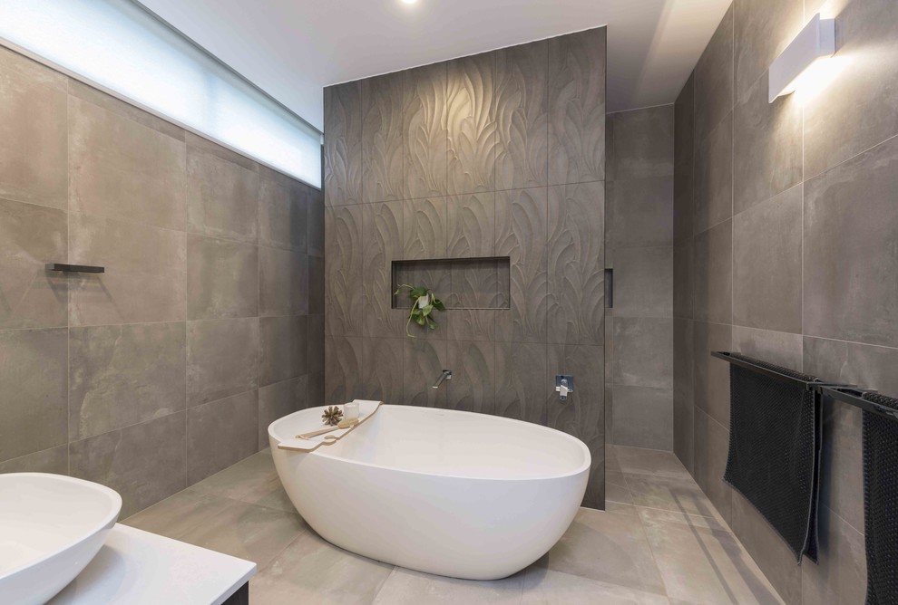 Design ideas for a contemporary master wet room bathroom in Melbourne with flat-panel cabinets, dark wood cabinets, a freestanding tub, brown tile, porcelain tile, grey walls, porcelain floors, a vessel sink, engineered quartz benchtops, an open shower and white benchtops.