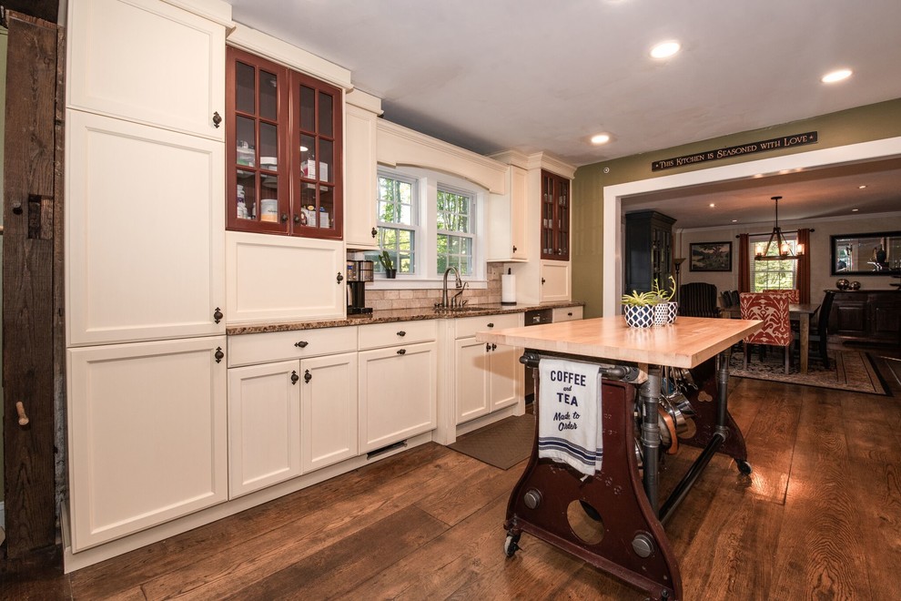 Photo of a large country galley eat-in kitchen in New York with a drop-in sink, shaker cabinets, white cabinets, granite benchtops, beige splashback, stone tile splashback, stainless steel appliances, medium hardwood floors, with island, brown floor and brown benchtop.