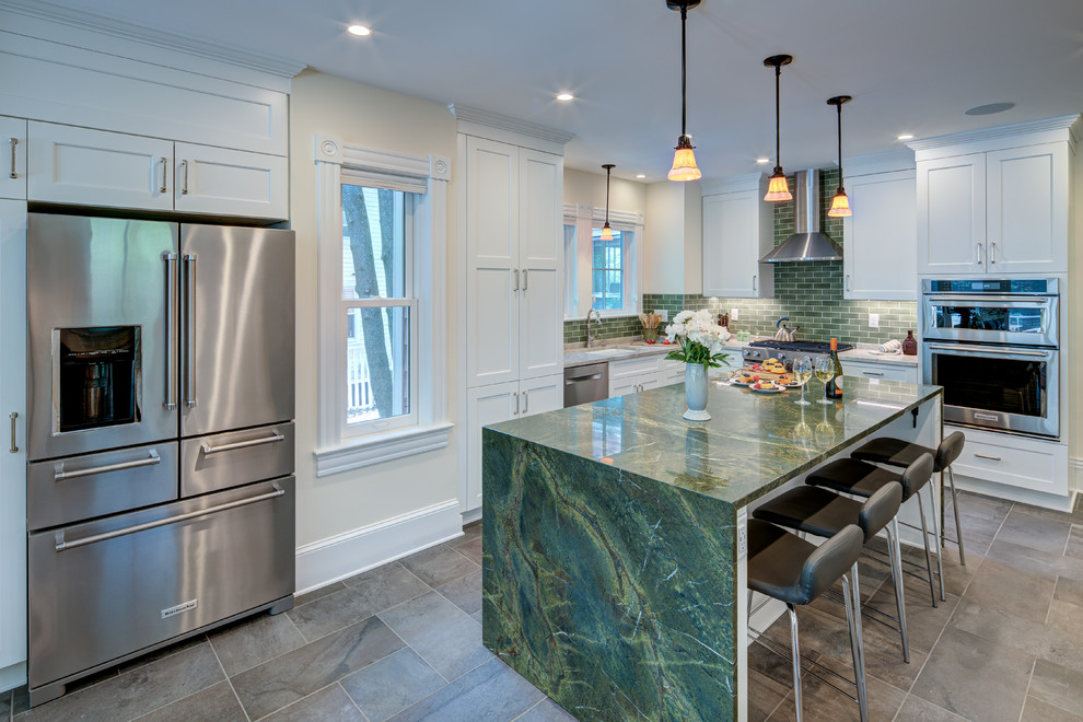 This is an example of a large transitional u-shaped open plan kitchen in DC Metro with an undermount sink, shaker cabinets, white cabinets, marble benchtops, green splashback, subway tile splashback, stainless steel appliances, slate floors, with island, black floor and green benchtop.