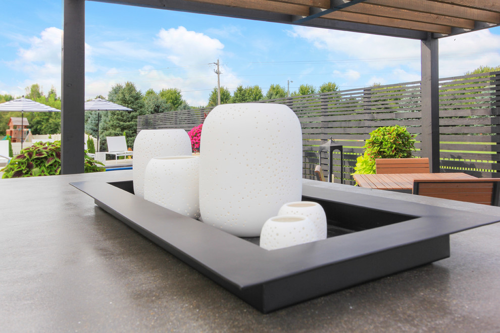 Large transitional backyard stamped concrete and rectangular lap pool fountain photo in Chicago