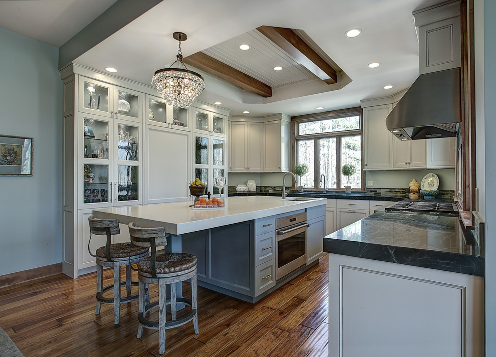 Transitional u-shaped dark wood floor kitchen photo in Grand Rapids with glass-front cabinets, gray cabinets, paneled appliances and an island
