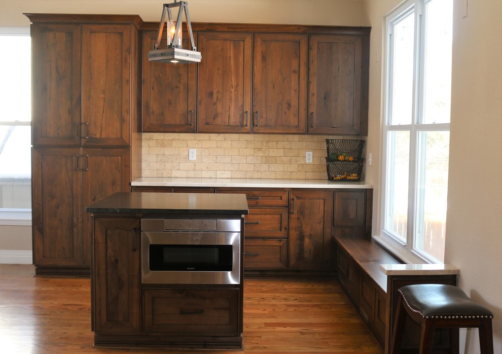 Example of a mid-sized transitional l-shaped medium tone wood floor and brown floor open concept kitchen design in Denver with recessed-panel cabinets, medium tone wood cabinets, granite countertops, beige backsplash, stone tile backsplash, stainless steel appliances, two islands and multicolored countertops