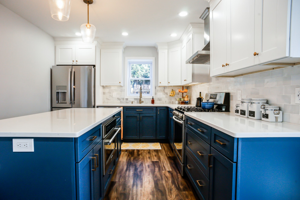 Idee per una cucina chic con ante in stile shaker, ante blu, top in quarzo composito, paraspruzzi bianco, paraspruzzi in marmo, pavimento in vinile, pavimento marrone e top bianco