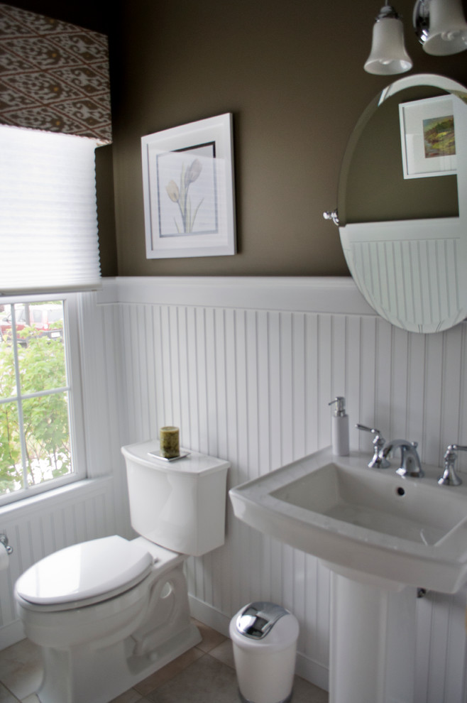 Photo of a small traditional powder room in Boston with a two-piece toilet, brown walls, limestone floors and a pedestal sink.
