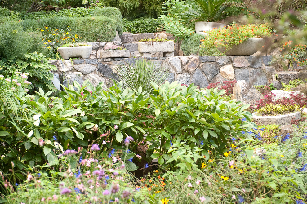 Eclectic sloped partial sun garden in New York with natural stone pavers.