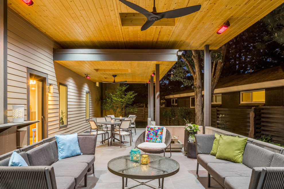 Mid-sized contemporary backyard patio in Denver with a fire feature, concrete pavers and a roof extension.