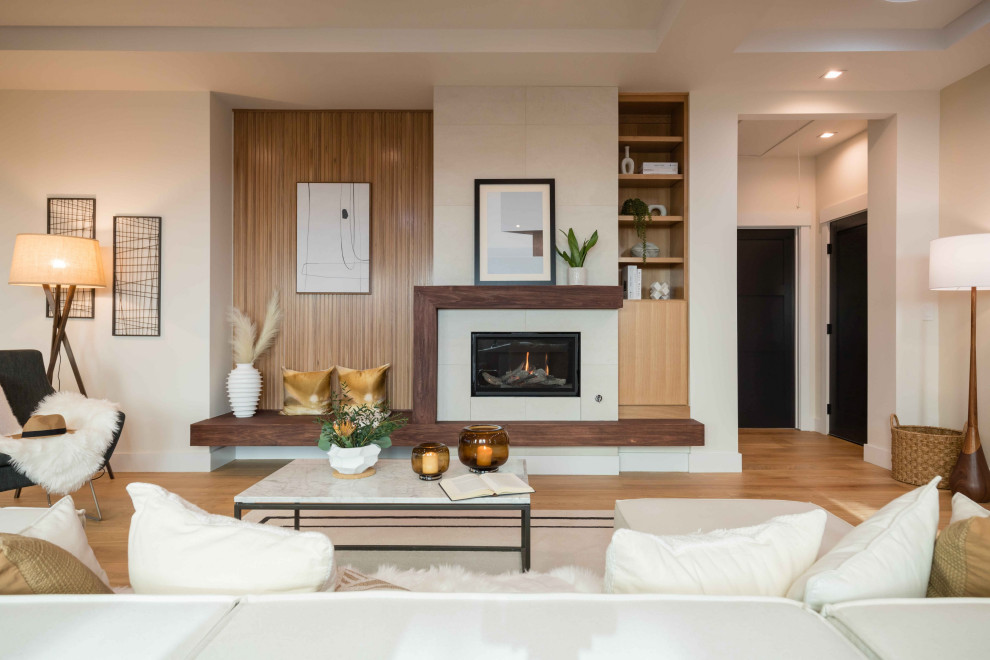 Example of a trendy open concept medium tone wood floor, brown floor and tray ceiling living room design in San Francisco with beige walls, a standard fireplace and a tile fireplace