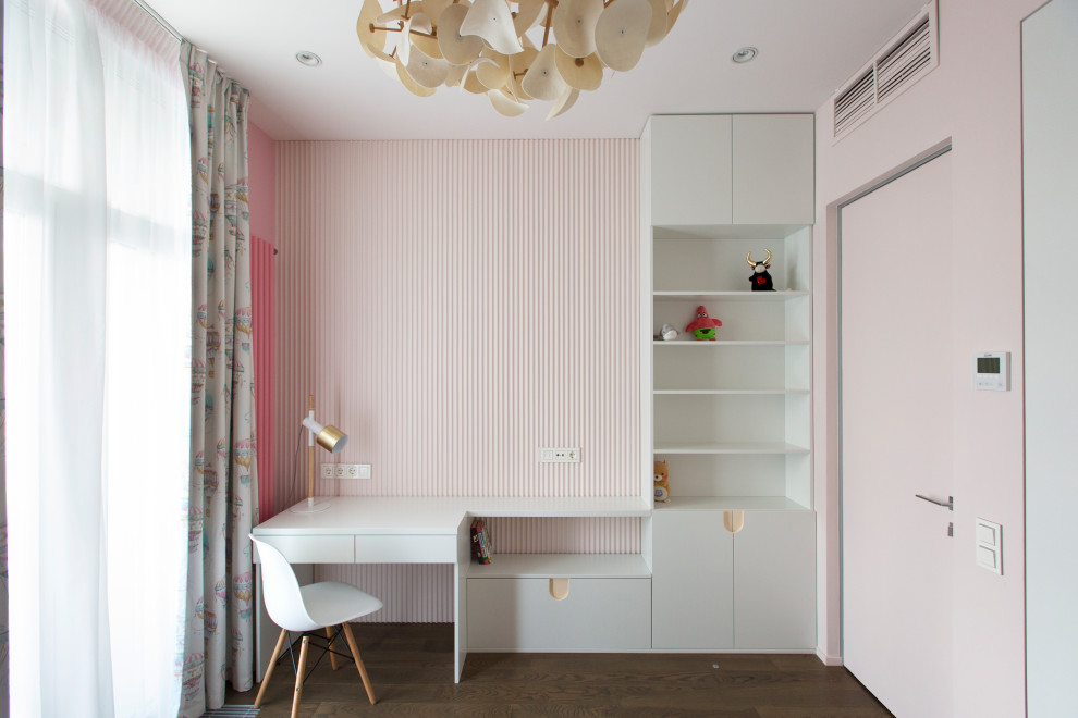 Modelo de dormitorio infantil de 4 a 10 años actual de tamaño medio con paredes rosas, suelo de madera en tonos medios, suelo marrón y todos los tratamientos de pared
