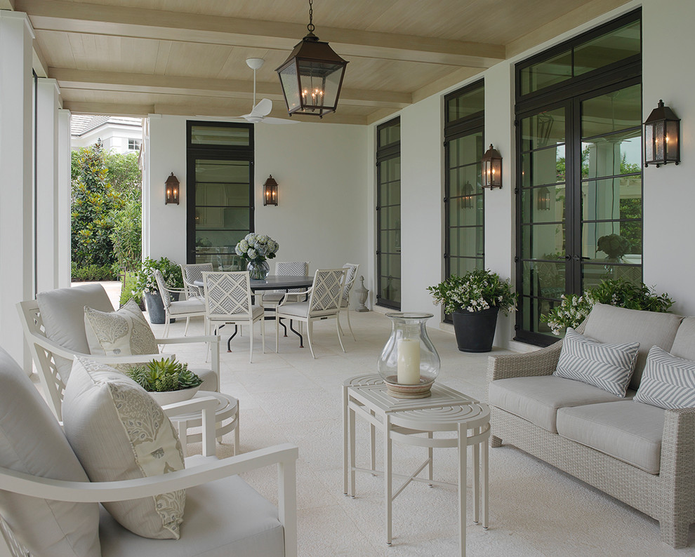 This is an example of a tropical backyard patio in Miami with a roof extension.