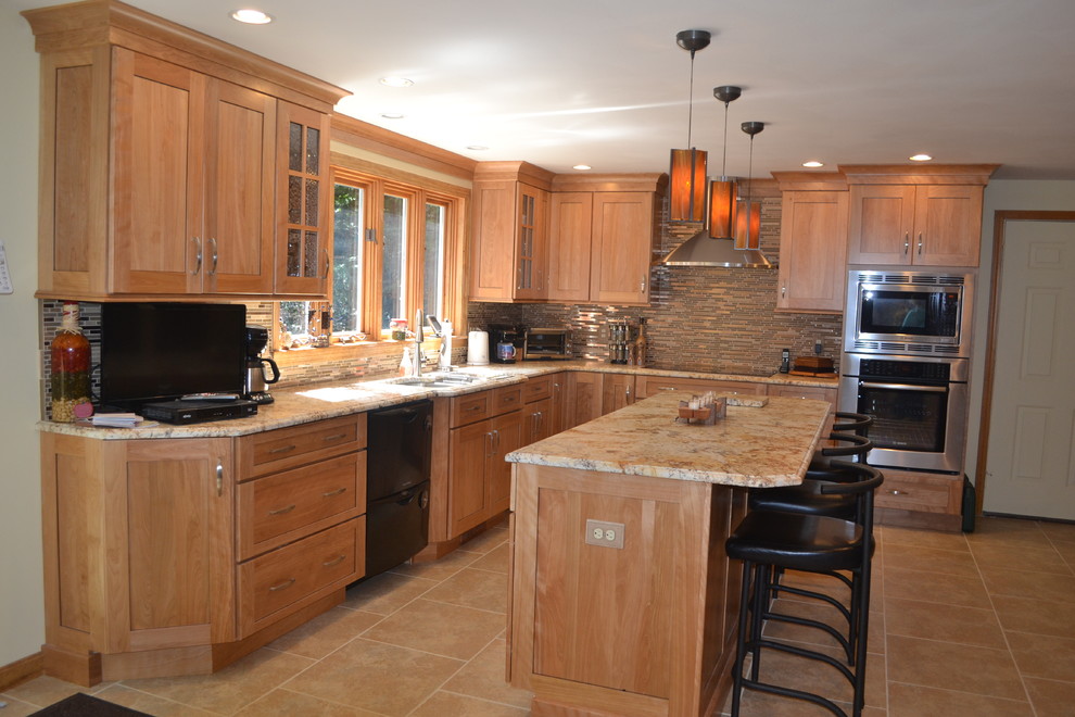 This is an example of a mid-sized traditional l-shaped eat-in kitchen in Boston with an undermount sink, shaker cabinets, medium wood cabinets, granite benchtops, metallic splashback, metal splashback, stainless steel appliances and ceramic floors.
