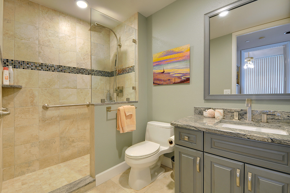 This is an example of a mid-sized contemporary kids bathroom in Tampa with an undermount sink, raised-panel cabinets, green cabinets, granite benchtops, a freestanding tub, a corner shower, a one-piece toilet, blue tile, glass tile, blue walls and porcelain floors.