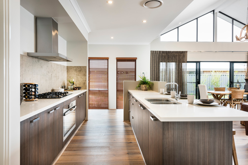 Mid-sized contemporary galley kitchen pantry in Perth with an undermount sink, flat-panel cabinets, medium wood cabinets, beige splashback, stainless steel appliances, vinyl floors and with island.
