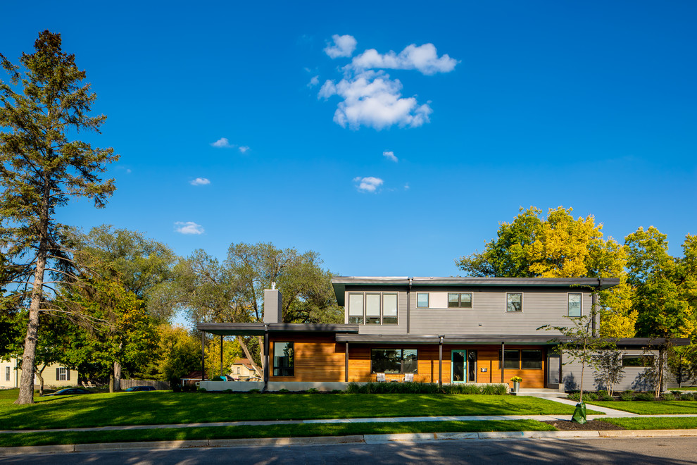 Inspiration for a midcentury two-storey grey exterior in Minneapolis with a flat roof.