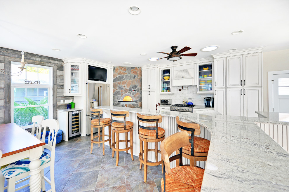 Photo of a beach style eat-in kitchen in Philadelphia with white cabinets and stainless steel appliances.