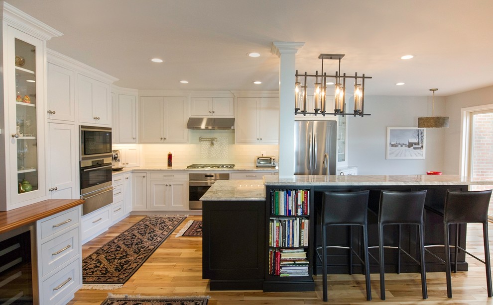 Inspiration for a transitional eat-in kitchen in Philadelphia with an undermount sink, flat-panel cabinets, white cabinets, granite benchtops, white splashback, stainless steel appliances, light hardwood floors and with island.
