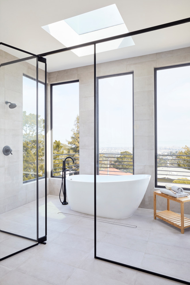 Design ideas for a large contemporary grey and white ensuite wet room bathroom in San Francisco with a freestanding bath, grey tiles, porcelain tiles, white walls, porcelain flooring, a submerged sink, grey floors, a hinged door, brown cabinets, engineered stone worktops, white worktops and double sinks.