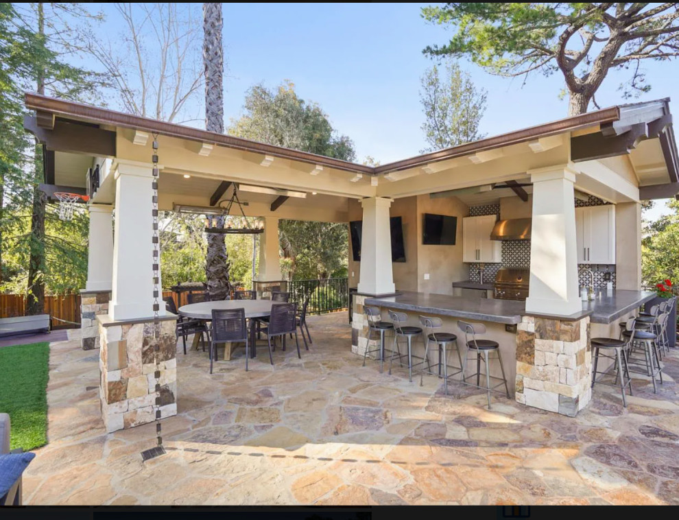 Patio kitchen - large transitional backyard stone patio kitchen idea in Other with a gazebo