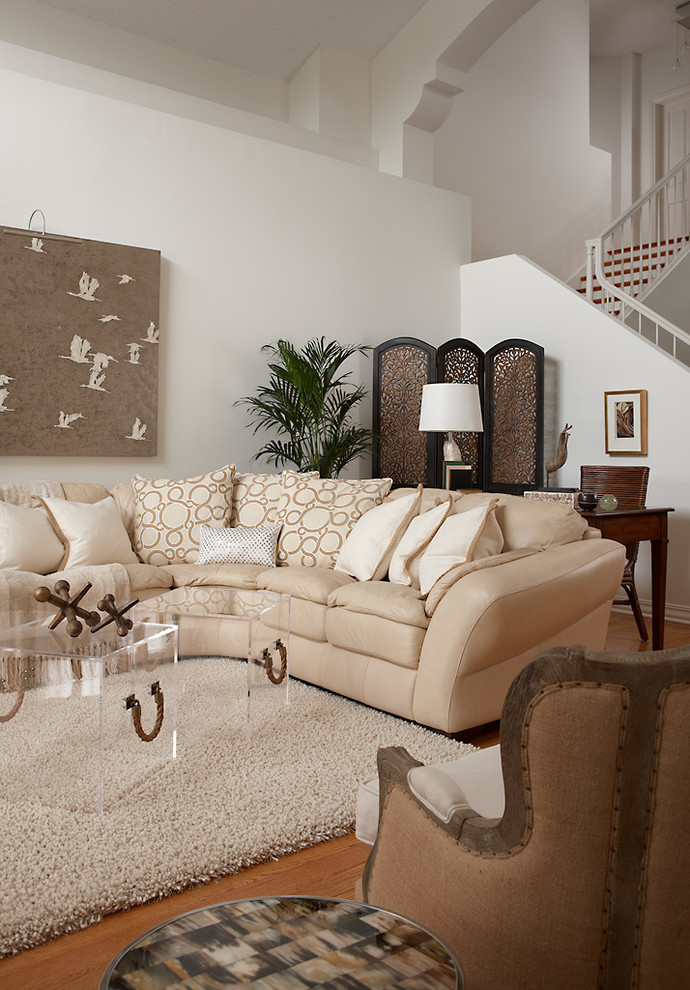 This is an example of a mid-sized traditional open concept living room in Other with beige walls, light hardwood floors and a built-in media wall.