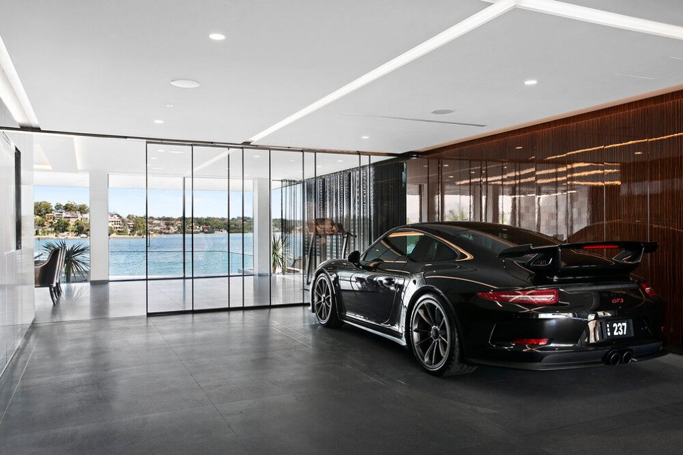 Photo of a large contemporary attached four-car garage in Sydney.