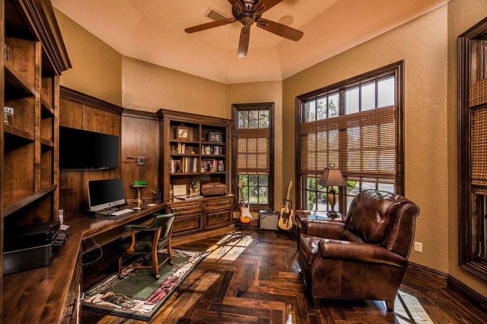 This is an example of a large traditional study room in Other with beige walls, dark hardwood floors, no fireplace and a built-in desk.