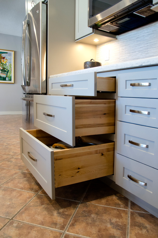 Open concept kitchen - mid-sized transitional u-shaped open concept kitchen idea in Miami with an undermount sink, shaker cabinets, gray cabinets, quartzite countertops, gray backsplash, porcelain backsplash, stainless steel appliances and an island
