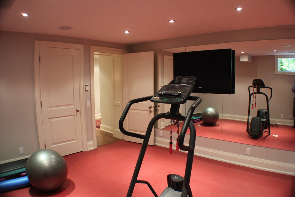 Design ideas for a contemporary home gym in Toronto with red floor.