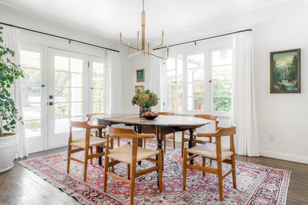 Photo of a mid-sized eclectic dining room in Los Angeles with white walls, dark hardwood floors and brown floor.