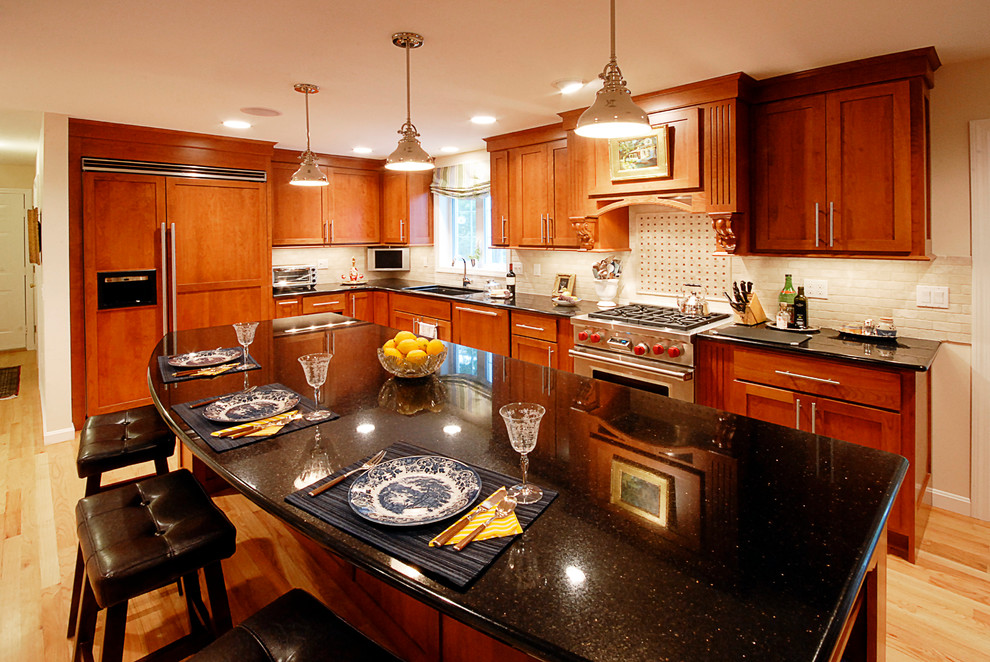 Photo of a traditional eat-in kitchen in Boston with an undermount sink, shaker cabinets, medium wood cabinets, granite benchtops, beige splashback, ceramic splashback, stainless steel appliances, light hardwood floors and with island.