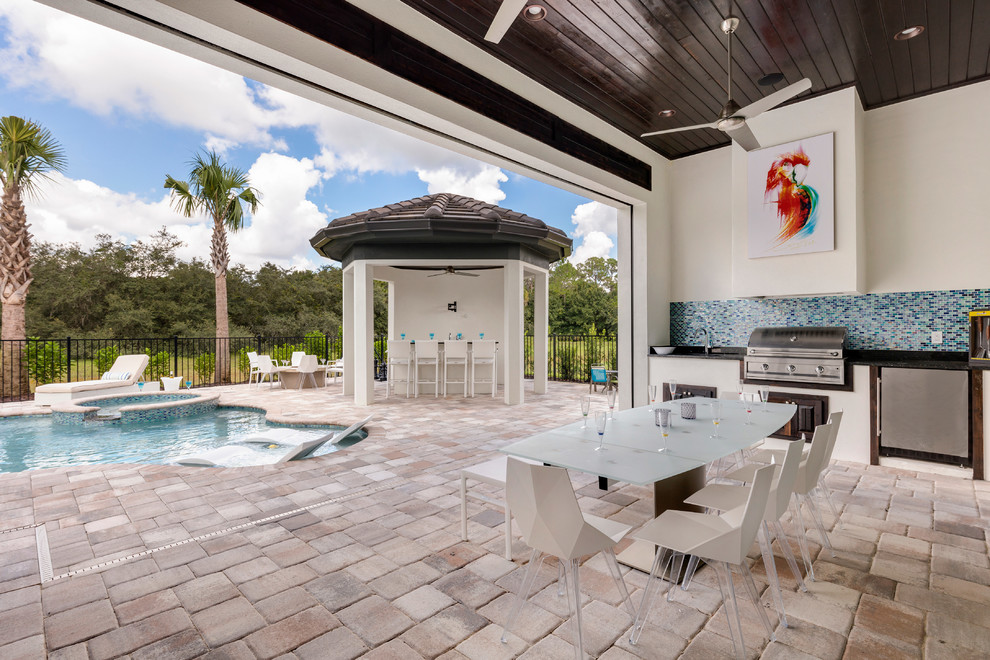 This is an example of a large contemporary backyard patio in Orlando with concrete pavers.