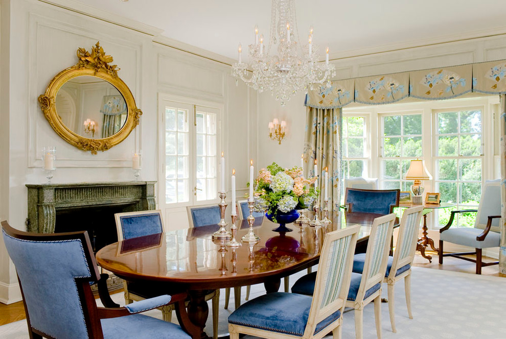 This is an example of a traditional dining room in Baltimore with white walls, medium hardwood floors and a standard fireplace.