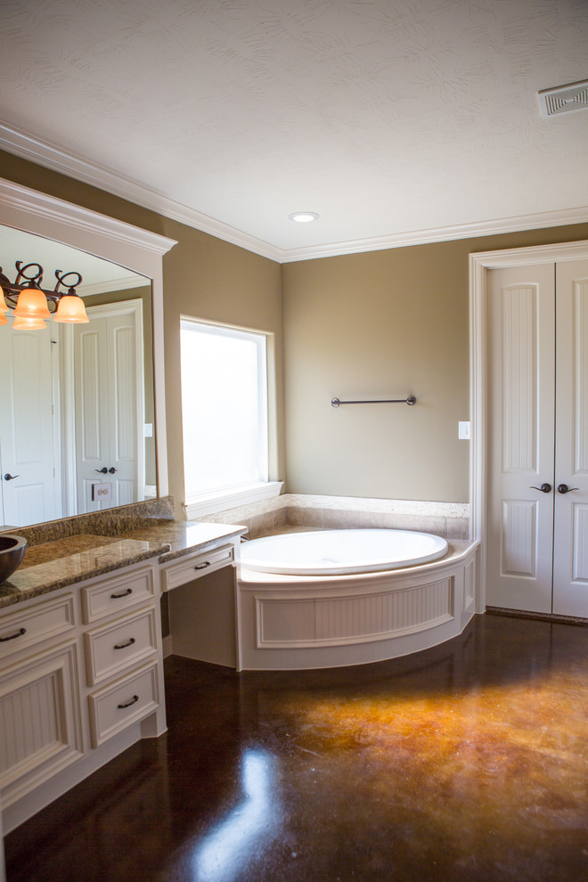 Design ideas for a mid-sized country 3/4 bathroom in Houston with a vessel sink, beaded inset cabinets, white cabinets, granite benchtops, a corner tub, an alcove shower, beige tile, terra-cotta tile, beige walls and concrete floors.