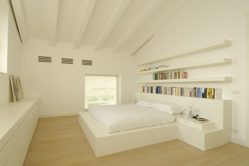 Photo of a modern bedroom in Other with white walls, light hardwood floors and beige floor.