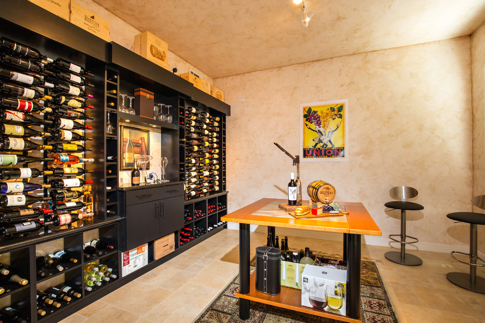 This is an example of a large contemporary wine cellar in San Diego with ceramic floors and display racks.