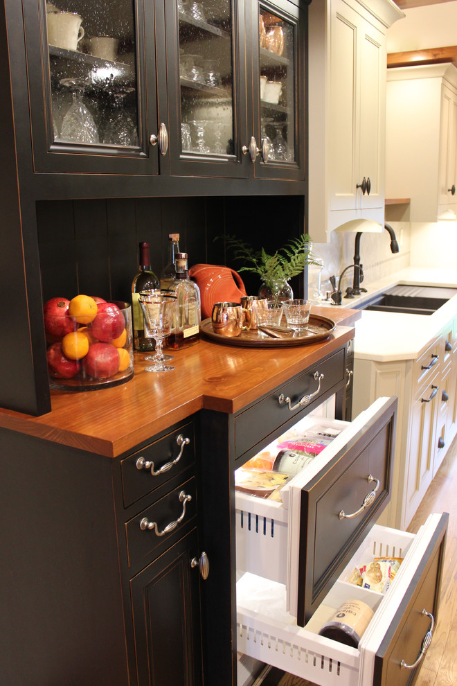 Example of a mid-sized mountain style u-shaped medium tone wood floor eat-in kitchen design with an undermount sink, shaker cabinets, white cabinets, solid surface countertops, brown backsplash, ceramic backsplash, stainless steel appliances and an island